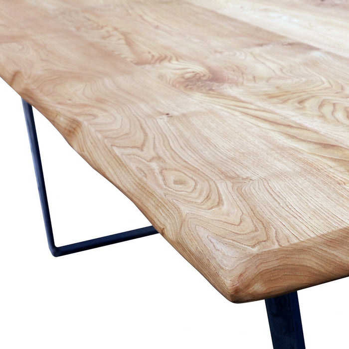 Close-up of the rounded corners and the rustic finish of the solid wood surface, showcasing the natural grain and texture