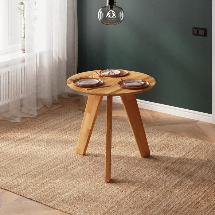 The Monroe kitchen table styled in a bright kitchen with dinnerware.