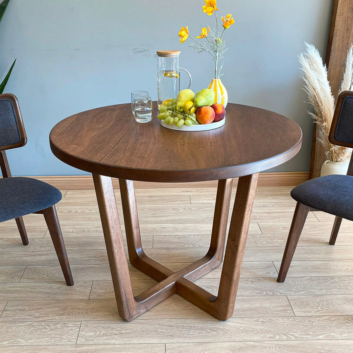The Muse mid-century round dining table, showcasing its elegant wood finish and modern design.