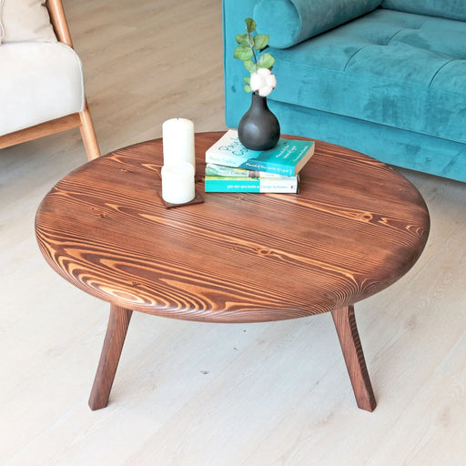 Full view of the mid-century modern round coffee table with tapered legs, highlighting its timeless style.