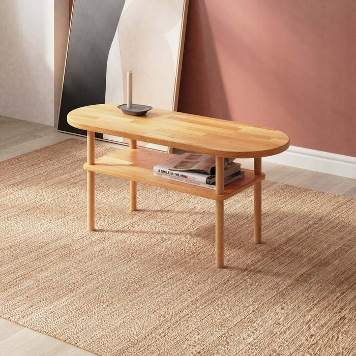 A side view of the Kennard beech wood oval coffee table featuring a minimalist design with smooth lines and a natural wood finish.