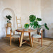 Full view of Amber Round Farmhouse Dining Table in a bright dining room.