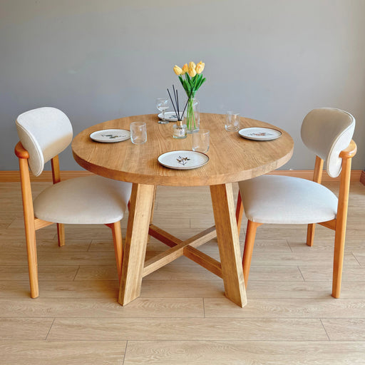Side view highlighting the sturdy solid wood legs of the Amber Round Farmhouse Dining Table.