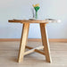 Wide shot of the Amber Round Farmhouse Dining Table with ambient lighting for an elegant look.