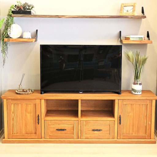 Front view of a solid pine wood TV stand showcasing a farmhouse-inspired design with open shelves and sliding cabinet doors.