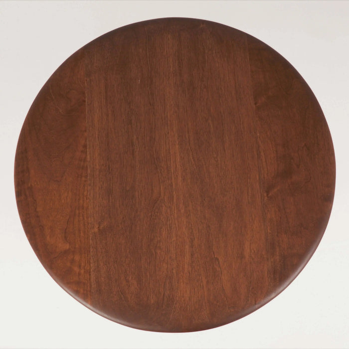 Bird's eye view of the round coffee table, highlighting its smooth surface and natural wood grains, showcasing the table's rustic charm and solid construction.