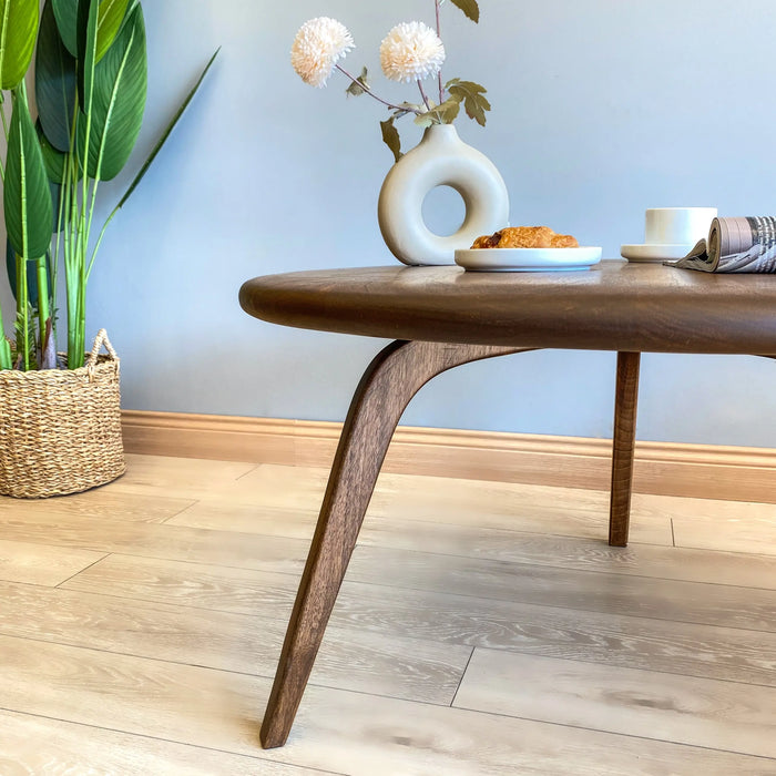 Close-up of the left leg of the round coffee table, showcasing the rounded connection detail and the craftsmanship of the solid pine wood.