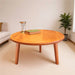 Bliss round wood cocktail table displayed in a modern living room with a sleek walnut finish.