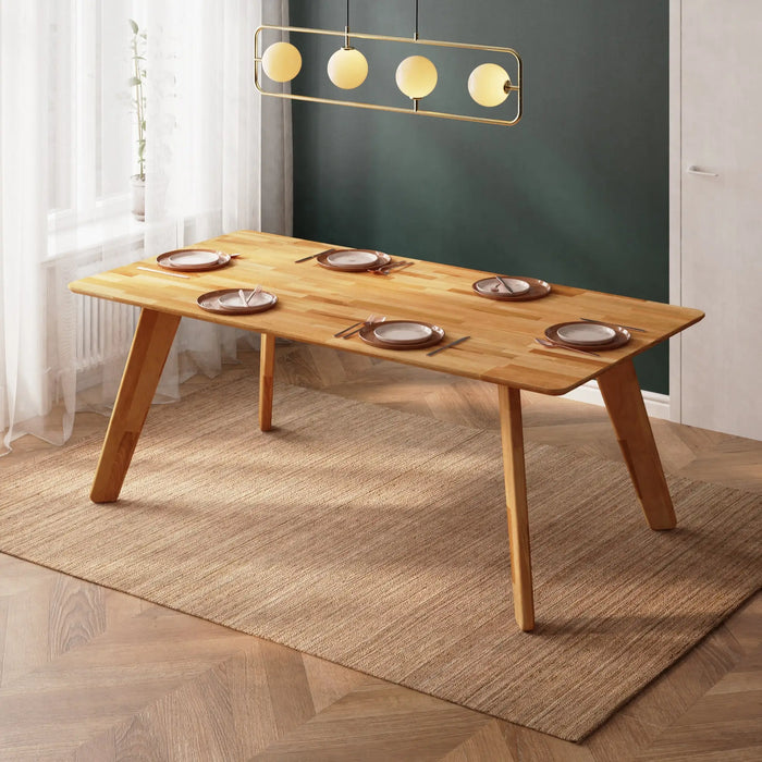 Wooden dining table styled in a bright dining room with farmhouse décor and natural lighting.