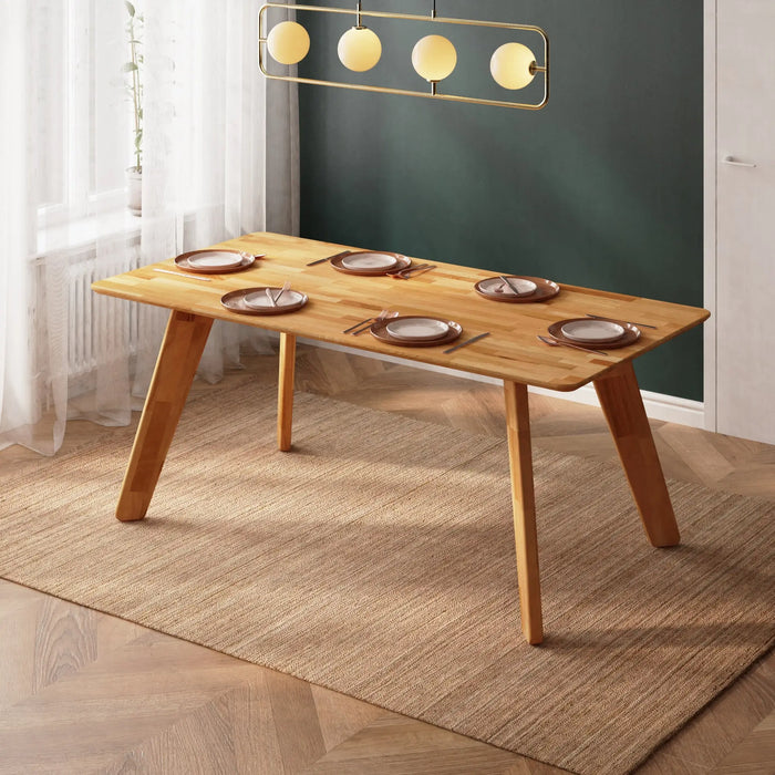 Wood dining room table styled with a centerpiece and surrounded by minimalist décor.