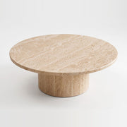 Top-angle studio view of Dune Round Travertine Coffee Table showing natural porous stone texture and cylindrical pedestal base
