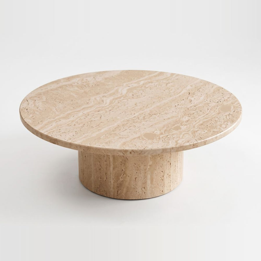 Top-angle studio view of Dune Round Travertine Coffee Table showing natural porous stone texture and cylindrical pedestal base