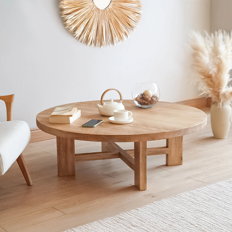A rustic round coffee table featuring a farmhouse-inspired design with a warm, natural wood finish, adding a charming touch to any living room.