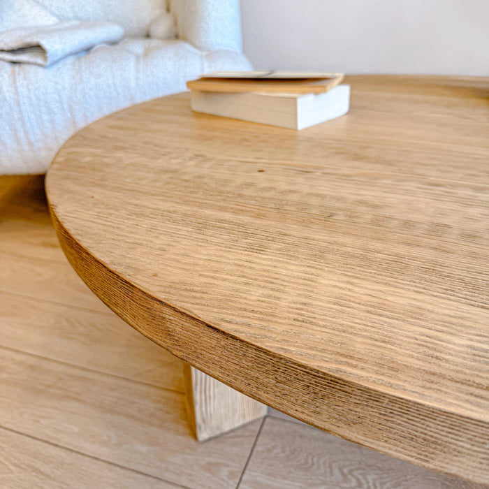 The Harlow round coffee table displayed with books and decorative items, emphasizing its versatile functionality.