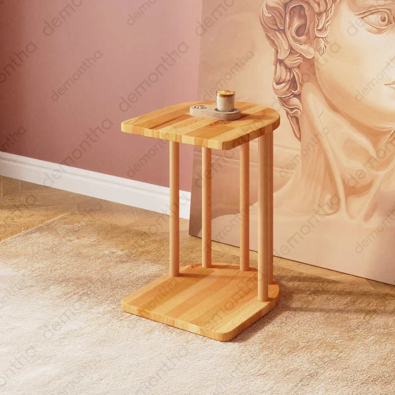 A Kyoto C-Shaped Wooden Side Table with a sleek minimalist design, crafted from solid wood, positioned beside a modern sofa.