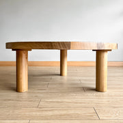 Minimalist coffee table with three cylindrical legs offers stability and a distinct design touch.