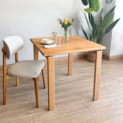 Minimalist Square Dining Table in natural beech wood finish placed in a bright Scandinavian dining room