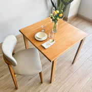 Modern wood dining table with clean lines and square top, made from solid beech