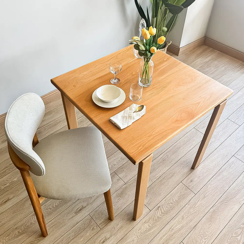 Modern wood dining table with clean lines and square top, made from solid beech