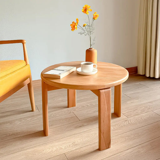  The Luna Minimalist Round Coffee Table in a modern living room, showcasing its sleek, handcrafted wood design.