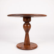 Mason Solid Walnut Round Pedestal Dining Table | Sculptural Base
 with a glossy dark brown finish, featuring a flared base and a decorative swan-neck style pedestal, photographed against a seamless white background.