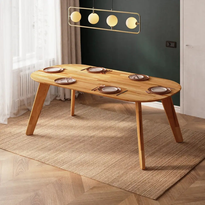 Monroe oval wood dining table illuminated by natural light, highlighting the smooth, elegant curves of the design.