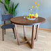The Muse dining table in a modern dining room setting, paired with chairs to create an inviting round dining table set