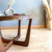 Close-up view of the right side of a solid walnut wood round coffee table, highlighting the sturdy construction, leg design, and quality craftsmanship.