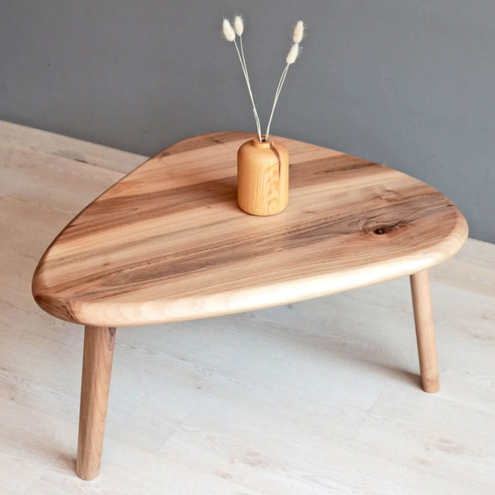 Single solid walnut coffee table with a mid-century modern design, featuring a smooth tabletop and tapered legs.