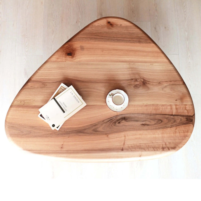 Top-down view of the single solid walnut oval coffee table, showing the smooth tabletop.