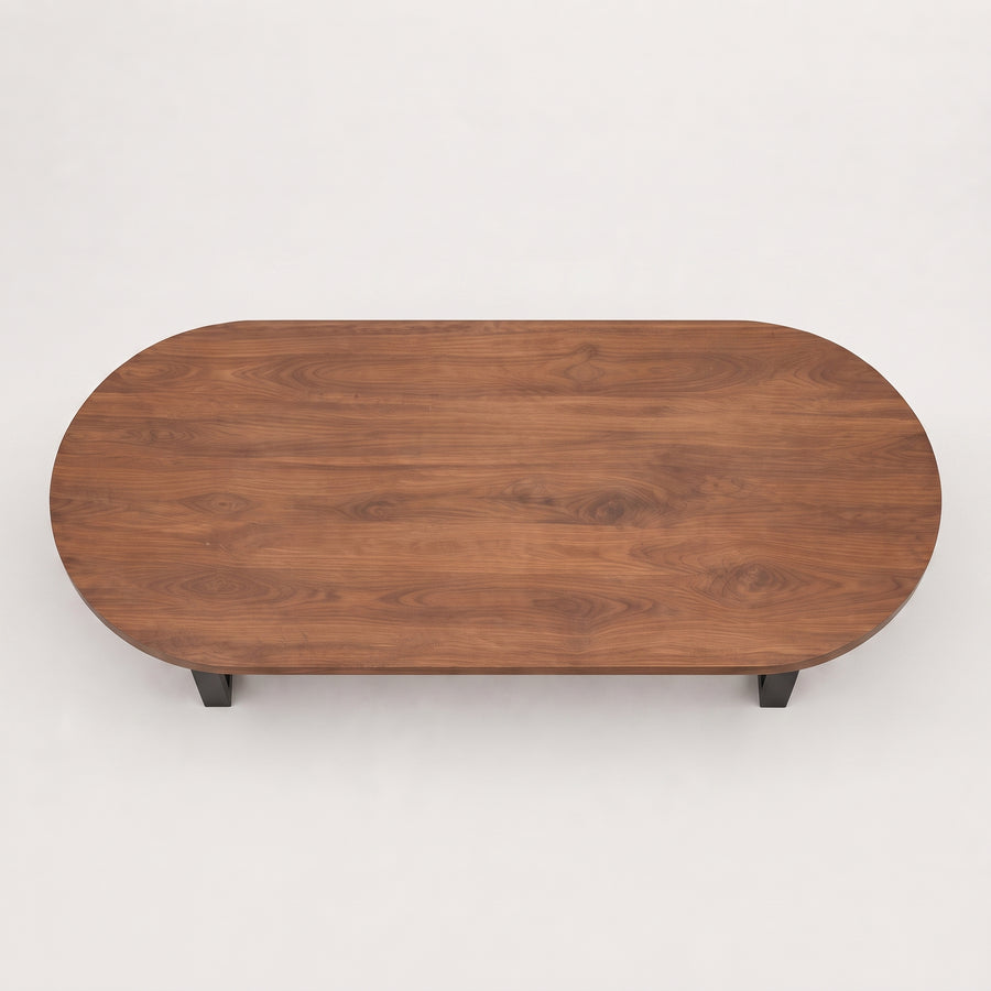 Oasis oval walnut coffee table with a rich walnut wood grain finish and small black metal legs, shown from a top-down perspective
