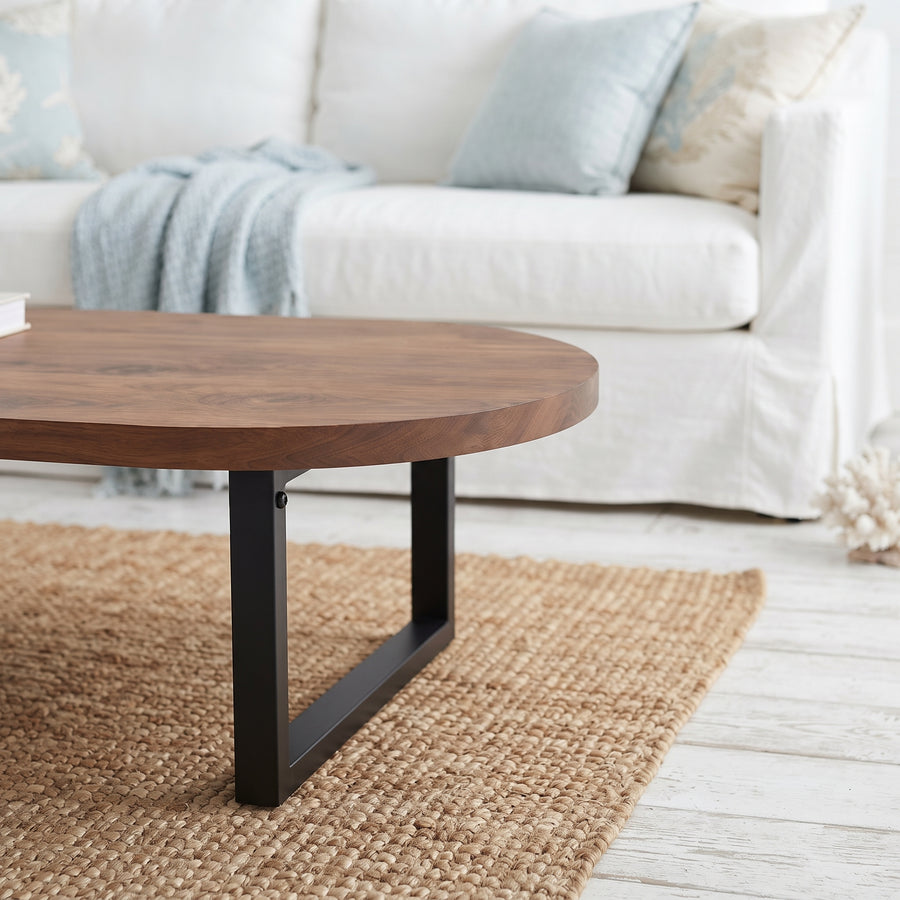 Oasis oval walnut coffee table with a walnut wood top and a black metal frame base