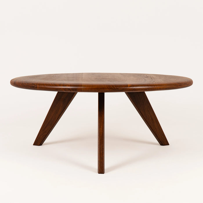 Mid-century modern coffee table on a white backgorund with its 3 legs focused