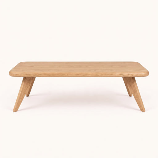 Petra Rectangular Oak Coffee Table with a light oak finish, featuring a rounded rectangular top and angled splayed legs, shown against a plain off-white background.