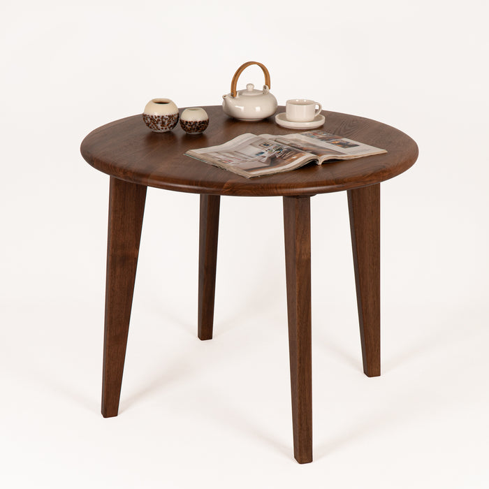 Zoomed-in view of Petra Round Wood Dining Room Table smooth edge detailing on the walnut tabletop.
