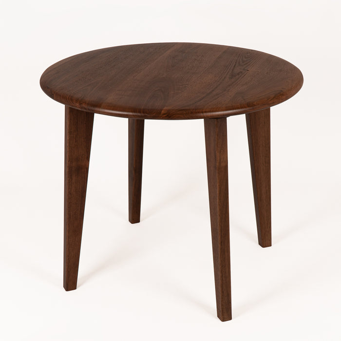 Close-up of the walnut wood grain texture on the round tabletop, emphasizing its craftsmanship.