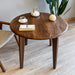 Overhead view of the round wood dining room table, revealing its spacious walnut tabletop