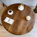 The round wood dining table styled with tableware, offering an elegant dining setup.