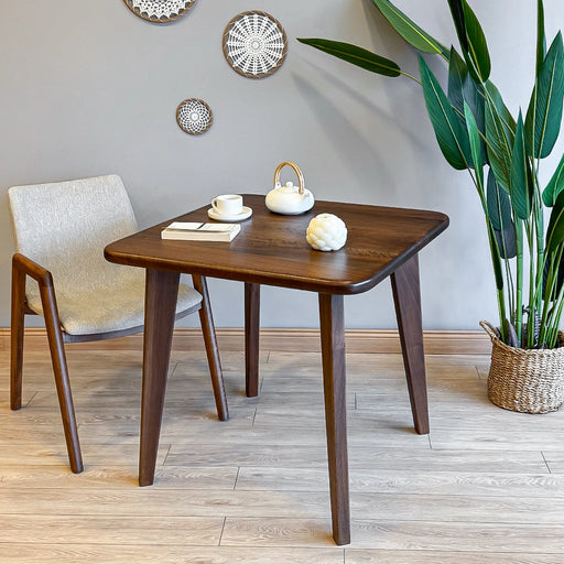 Close-up of the Petra Square Wood Dining Table showcasing its rich walnut finish and sleek mid-century design.