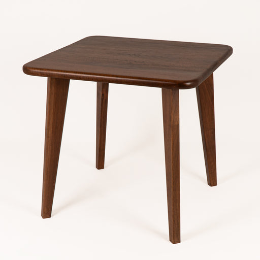 The entire Petra Square Wood Dining Table set with four chairs, emphasizing the modern yet timeless aesthetic.