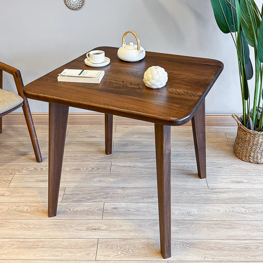 Close-up of the smooth, polished wood surface, highlighting the premium walnut material of the square dining table.