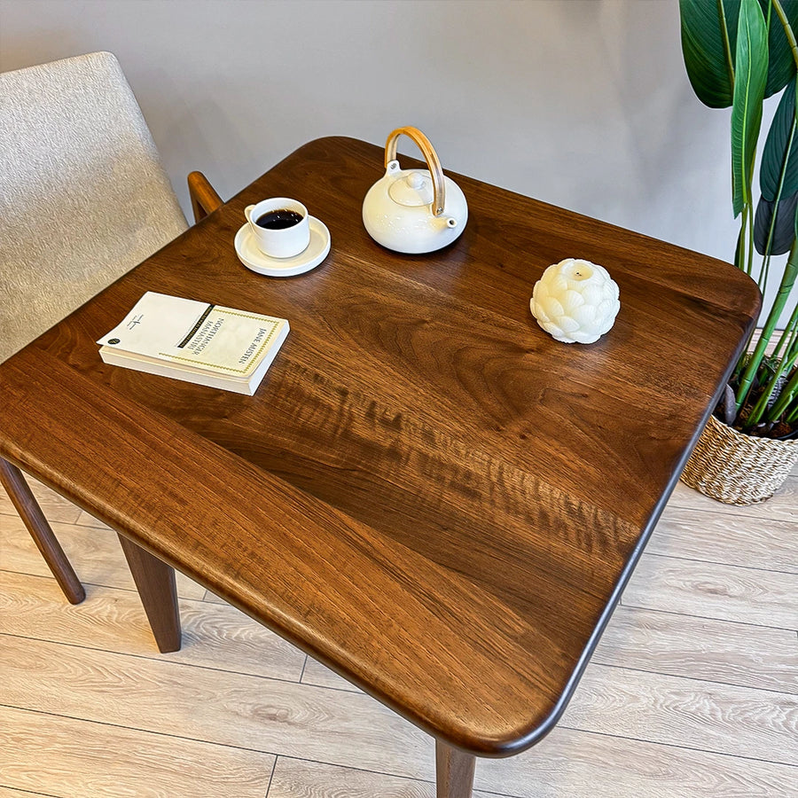 A wider shot featuring the table as the focal point of a cozy dining area with natural light.