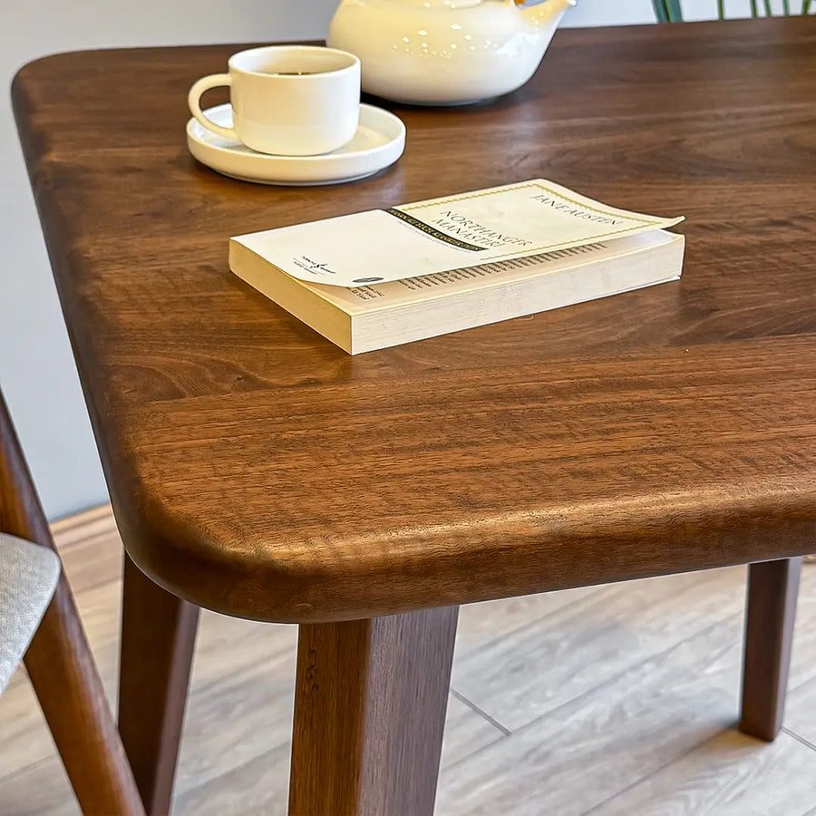 Detailed view of the table's legs, emphasizing the classic mid-century design and sturdy craftsmanship of the wood.