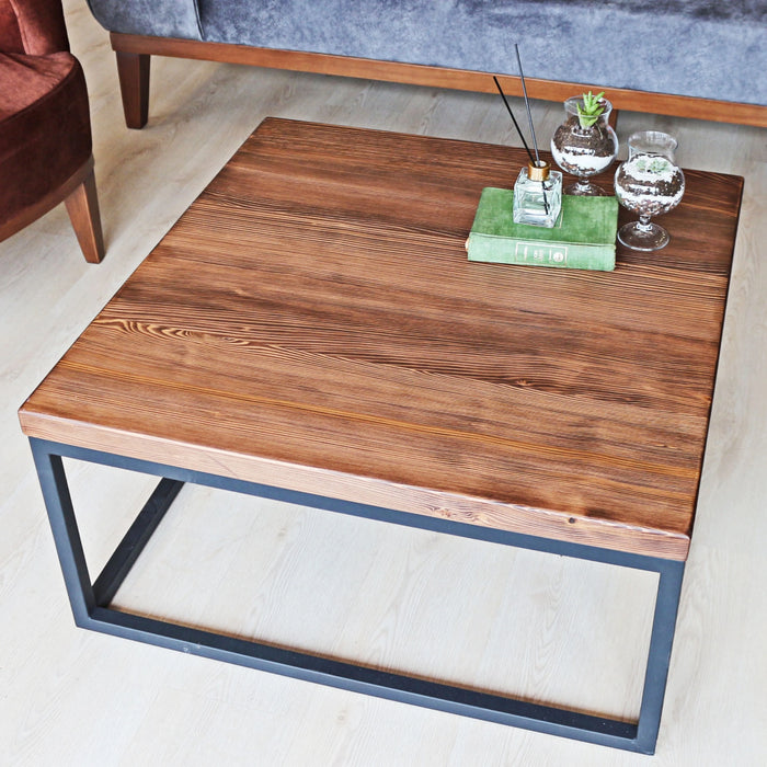 Slightly front-facing view of the Renton square wooden coffee table, showing its design and surroundings.