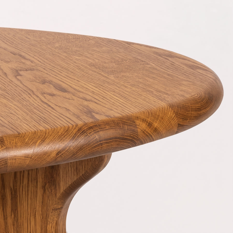 Close-up of Sidney Circular Dining Table Solid Oak Wood – Mid-Century Modern Design corner showing the natural oak wood grain and polished finish against a clean white background.
