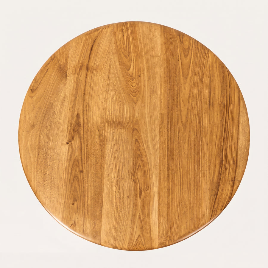 Sidney Circular Dining Table Solid Oak Wood – Mid-Century Modern Design tabletop with a warm medium-brown finish and visible wood grain patterns, photographed from directly above on a light off-white background.