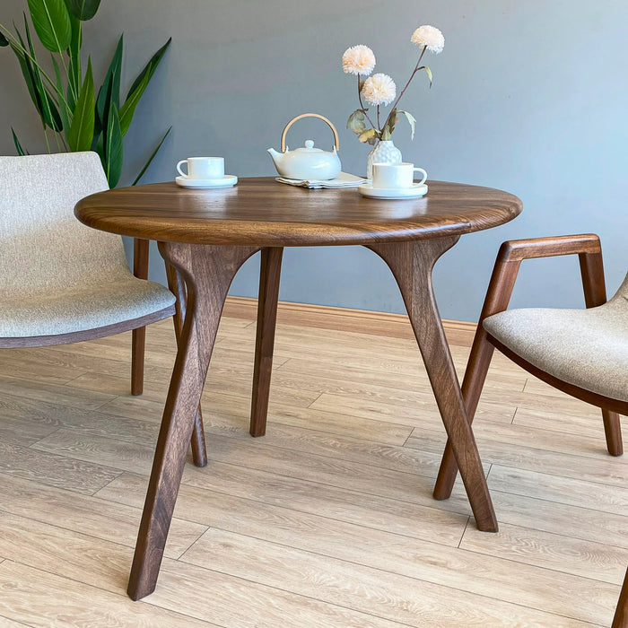 Wide shot of a dining area where the table anchors the room with its timeless design.