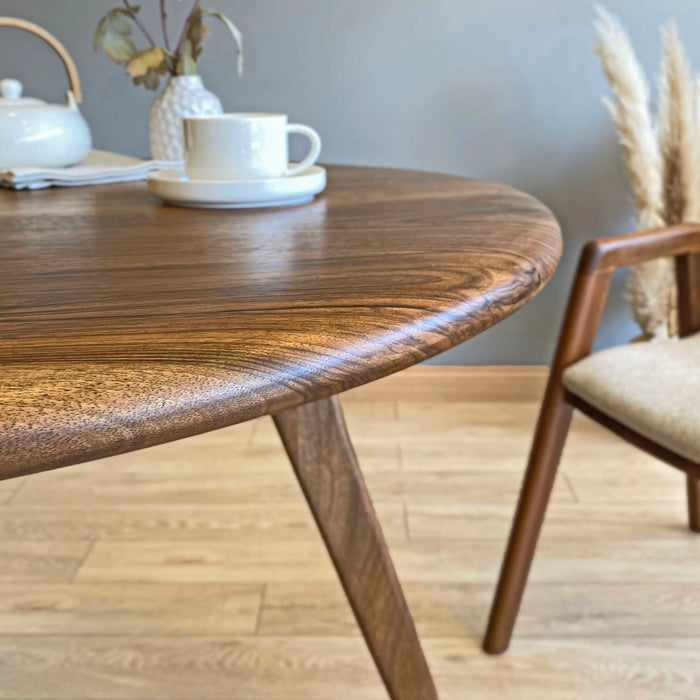 The walnut dining table with chairs tucked neatly under it, illustrating its practicality and style.