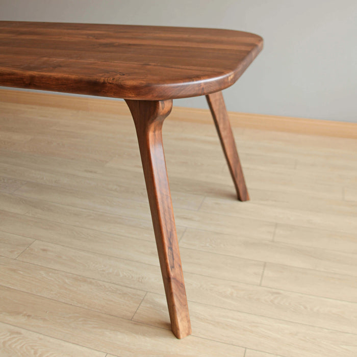 Profile shot of a premium wooden dining table, highlighting its clean proportions and durability.