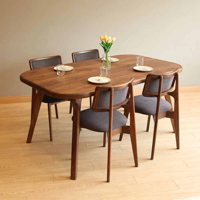 Side angle of a solid hardwood dining table showcasing smooth edges and tapered legs.